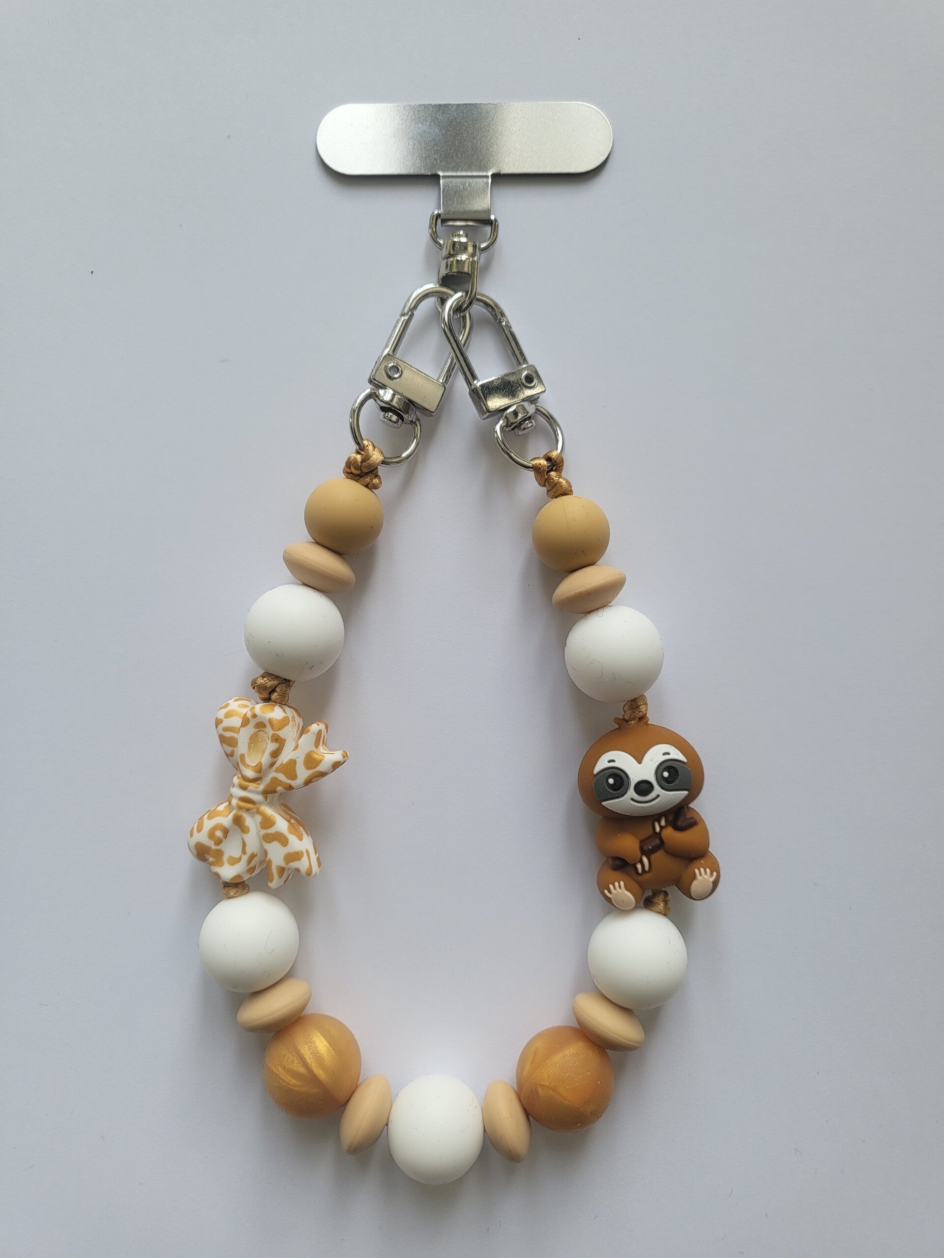 Telefoonkoord met luiaard in mat-goud, beige en wit.