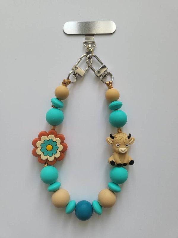 Telefoonkoord met koetje in petrol-blauw, beige en turquoise.