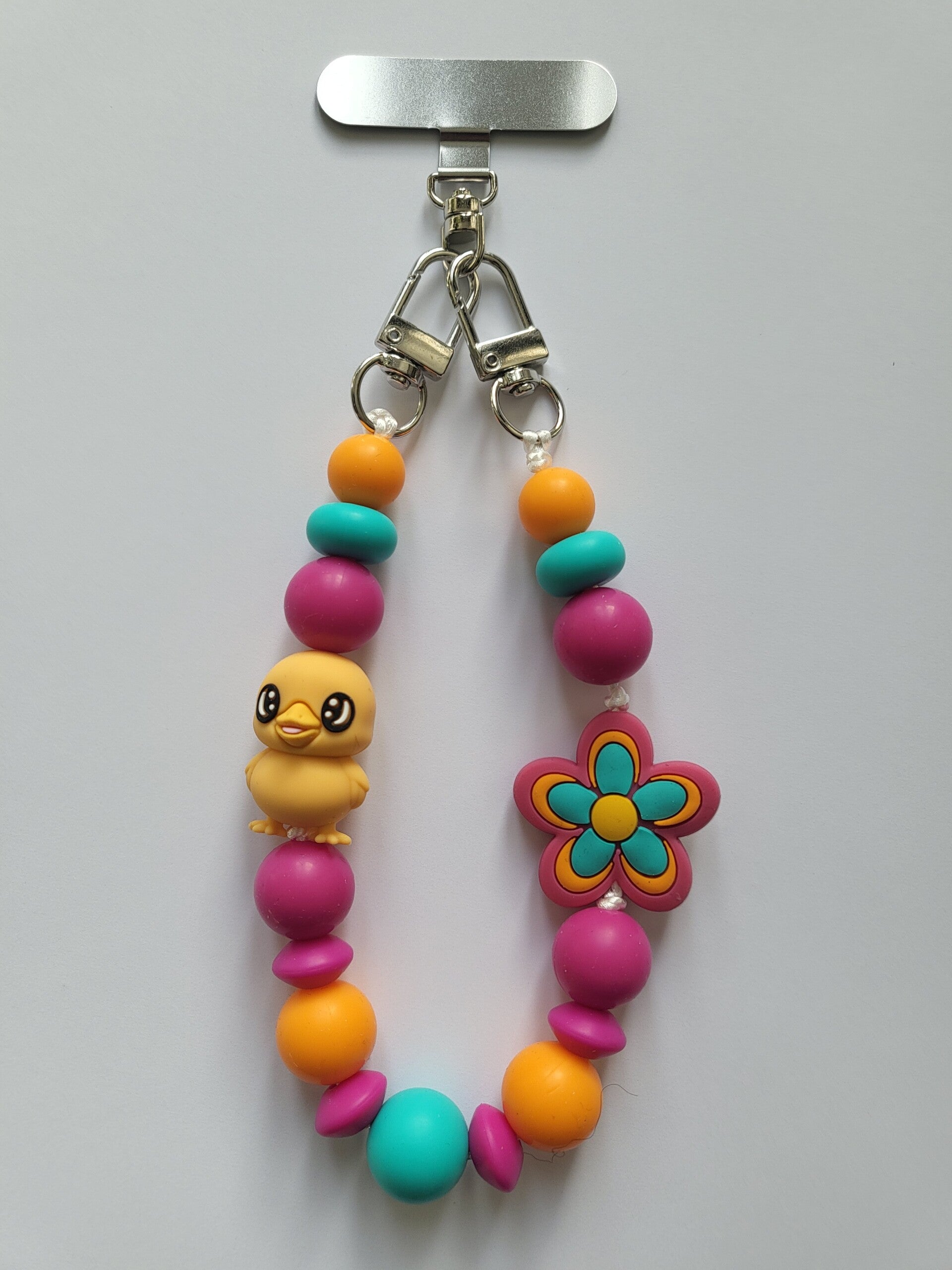 Telefoonkoord met kuikentje in fuchsia-roze, oranje en turquoise.