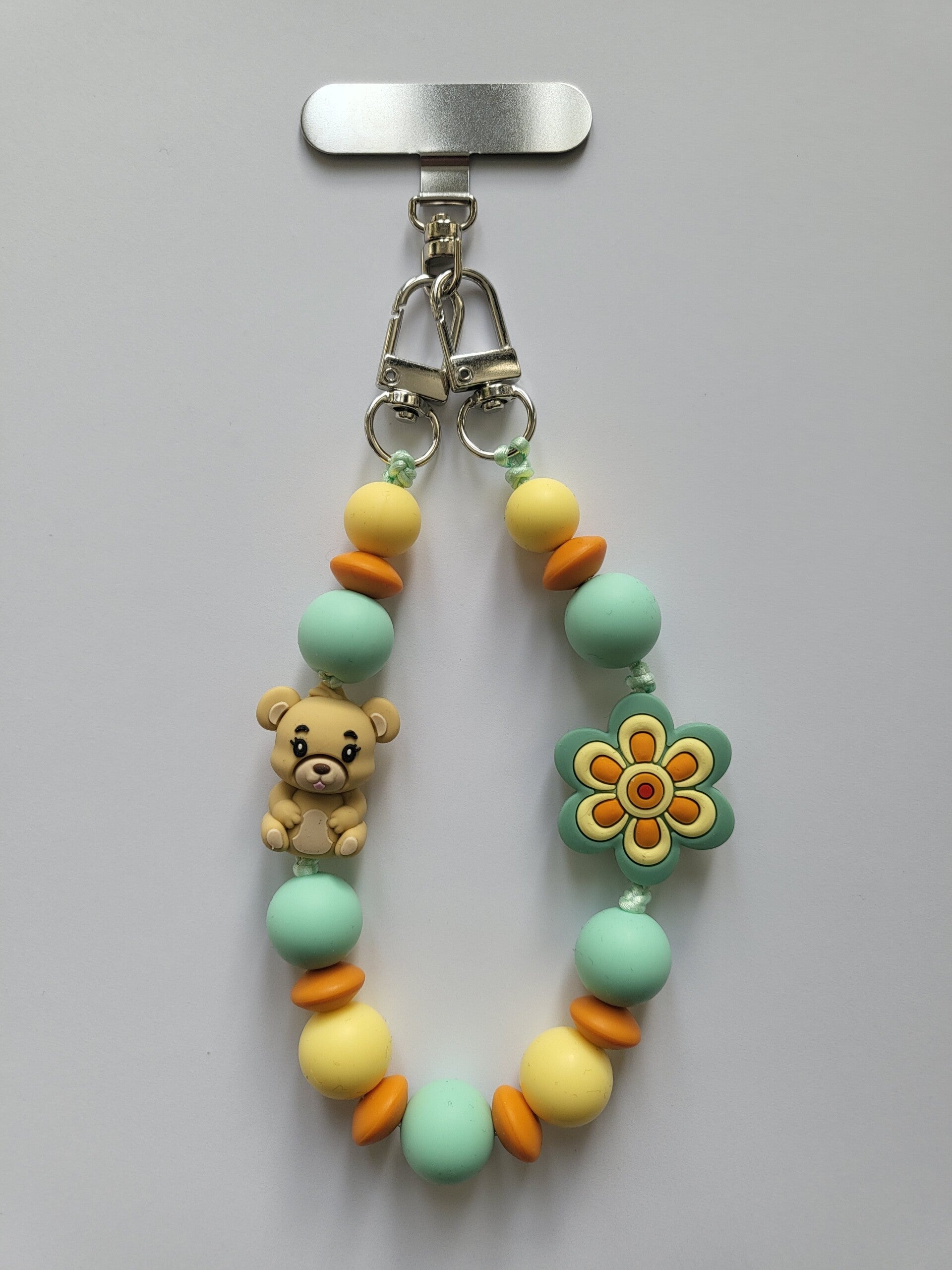 Telefoonkoord met beertje in lichtgeel, mintgroen, oranje en beige.