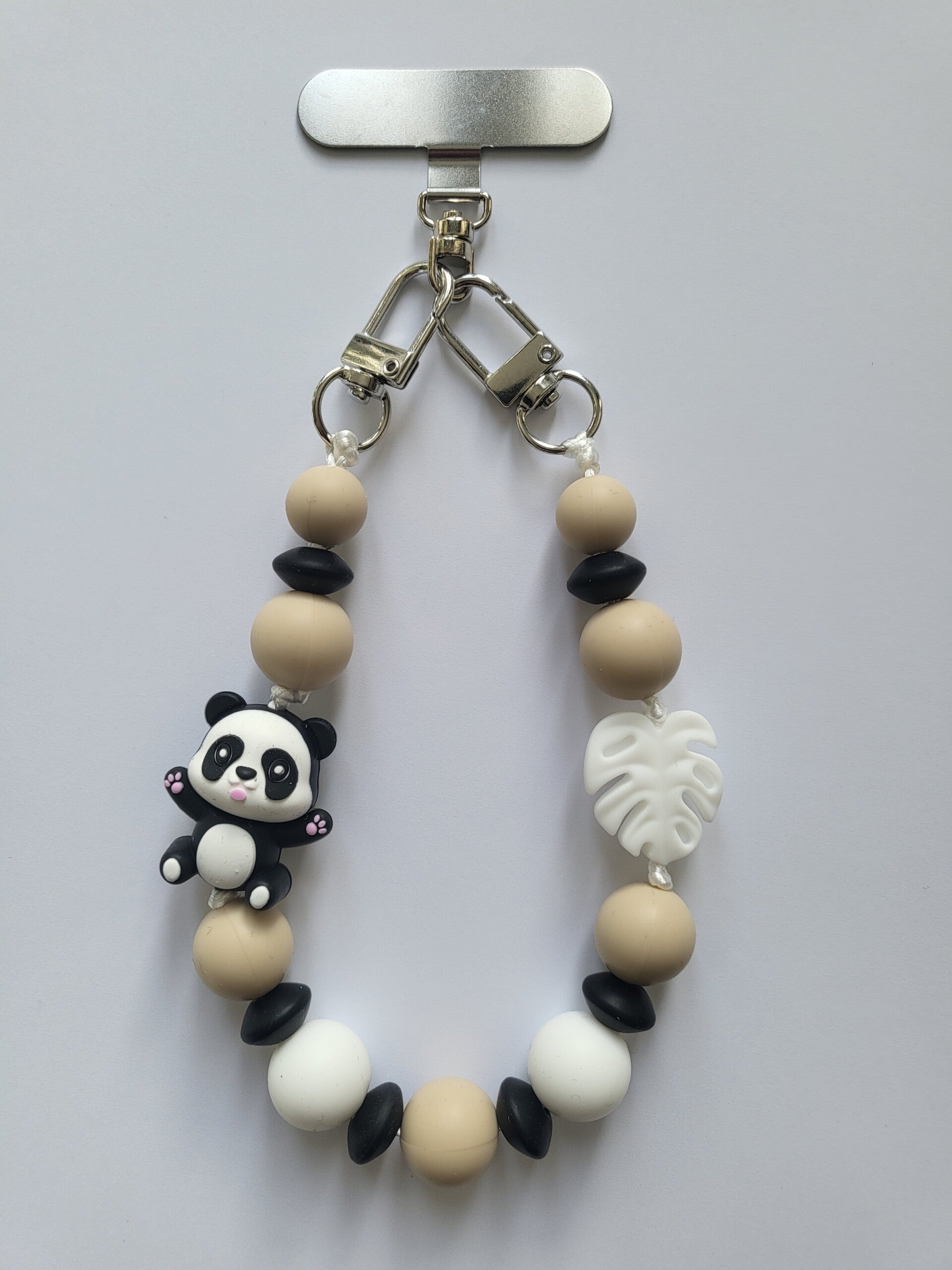 Telefoonkoord met panda beertje in zwart, wit en beige.