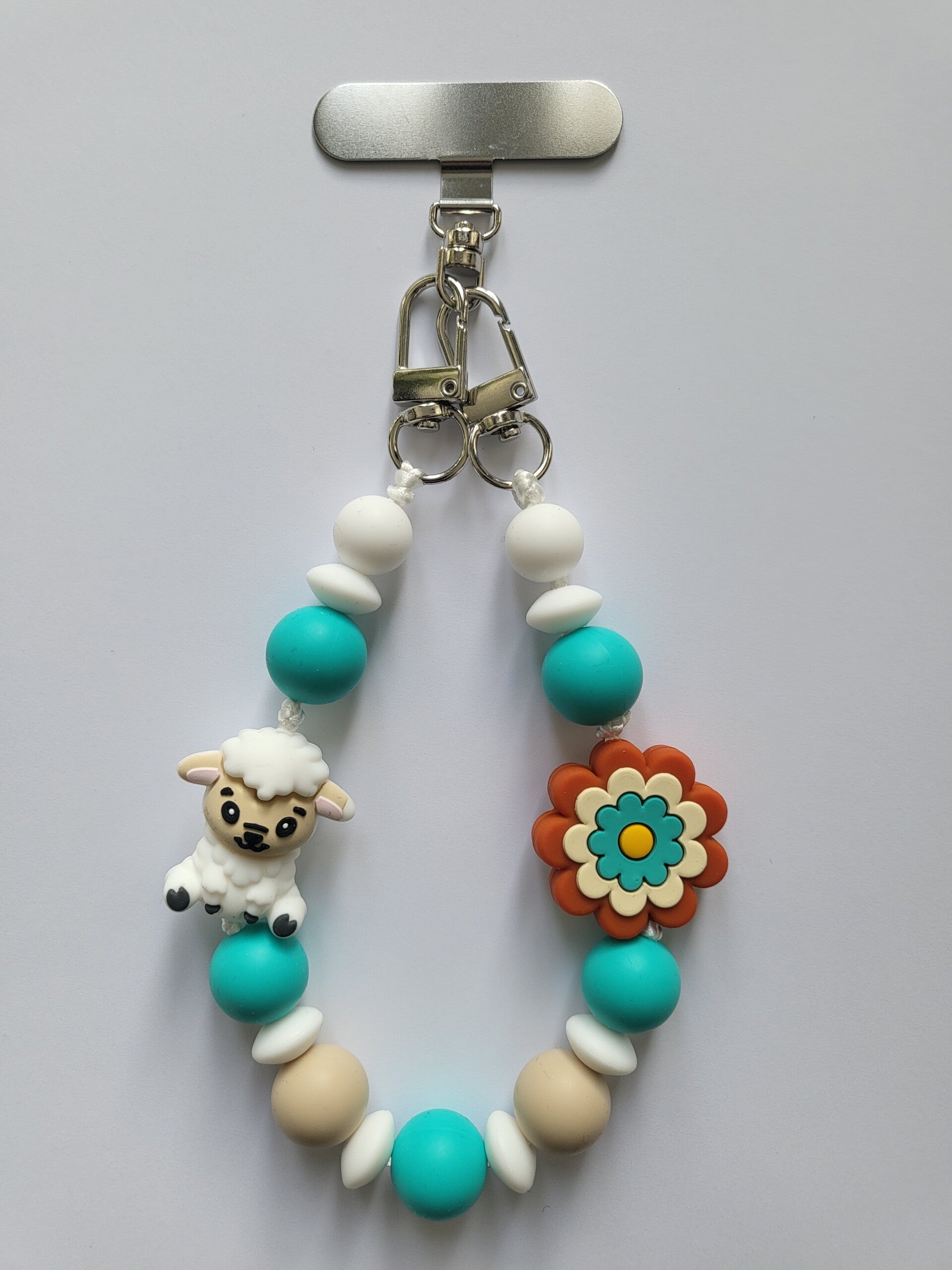 Telefoonkoord met schaapje in turquoise, beige, wit en roest.