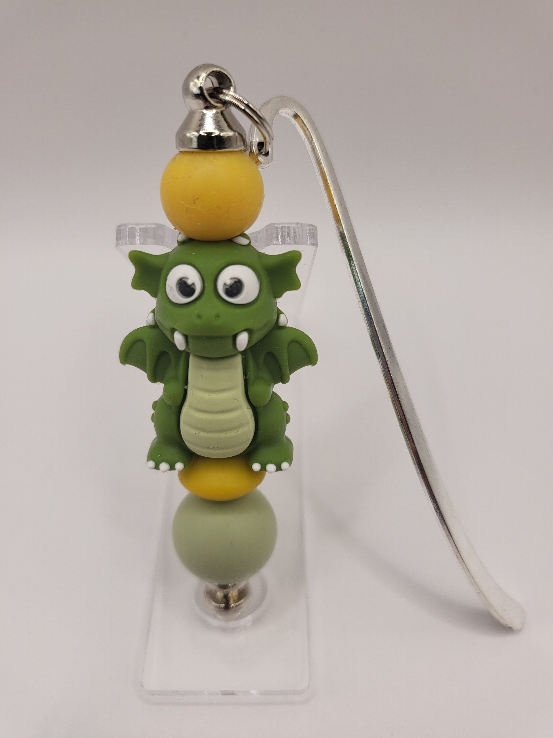 Boekenlegger met draakje in legergroen, matcha-groen en okergeel.