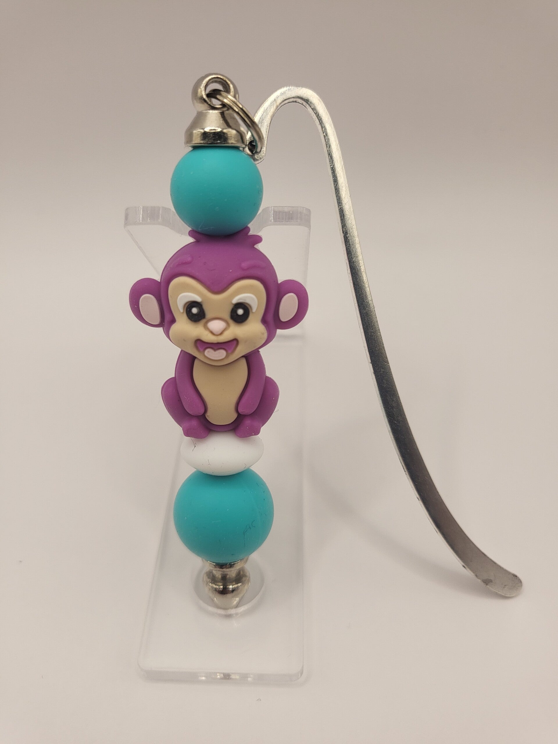 Boekenlegger met aapje in lila, turquoise en wit.