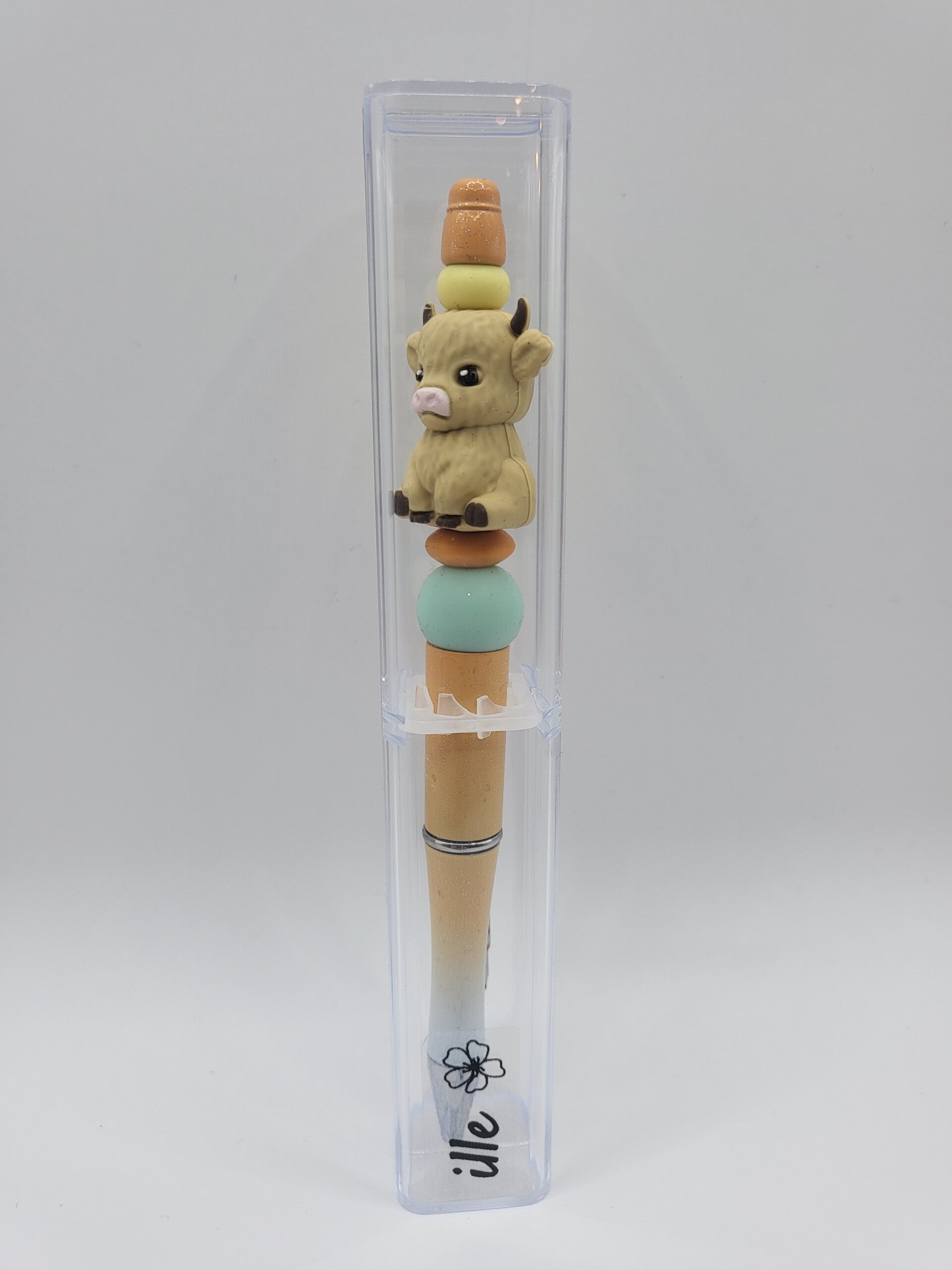 Pen met koetje in licht-geel, mintgroen, oranje en beige.