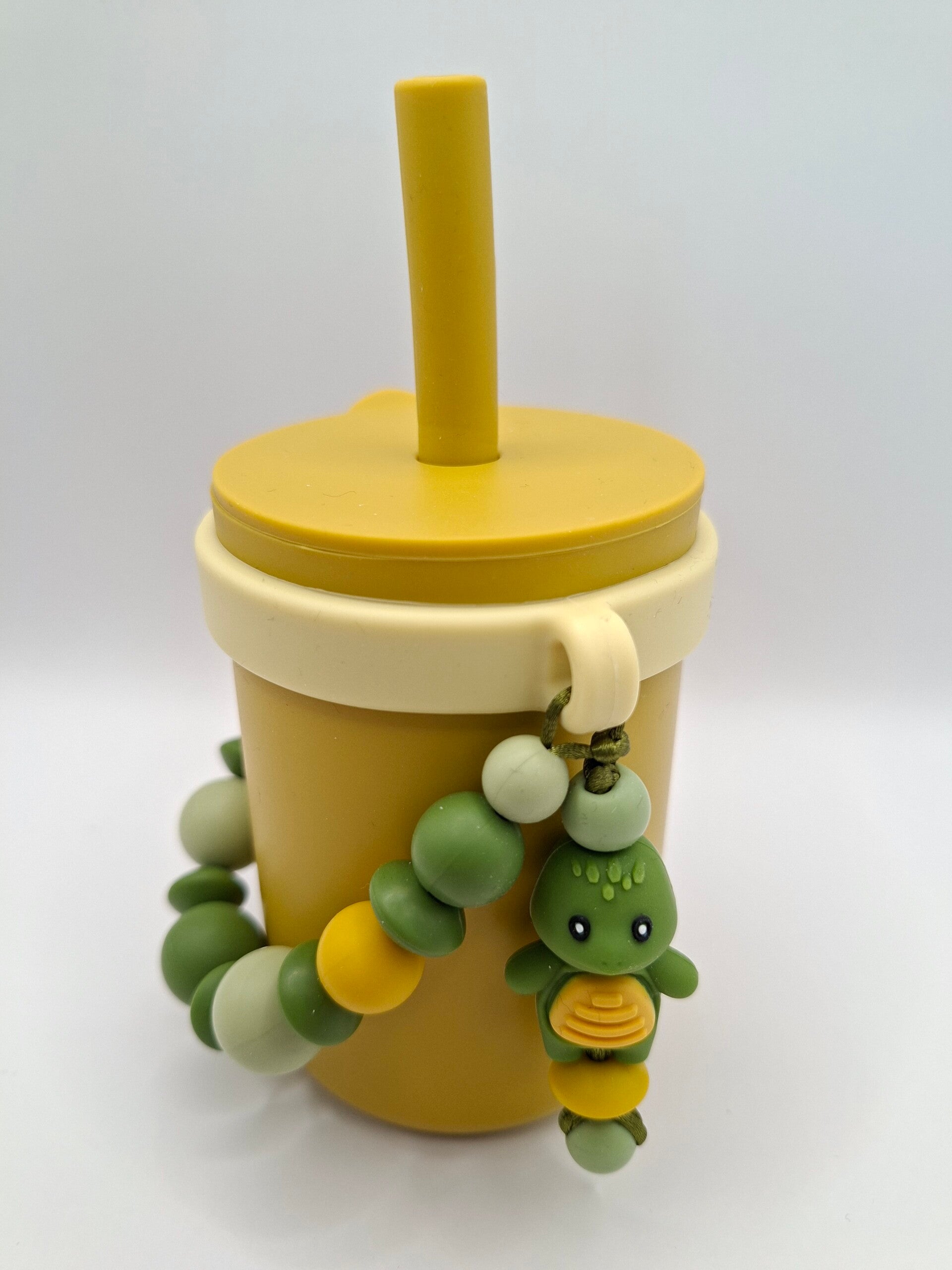 Silicone beker in oker-geel, met zacht gele afneembare silicone sier-ring.