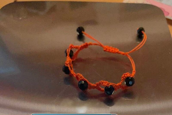 Pulsera trenzada con bola negra en anaranjado