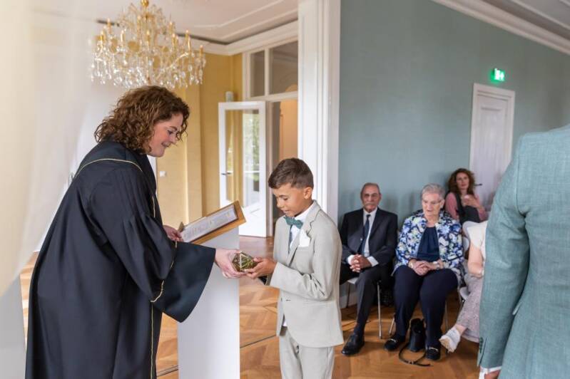 Trouwambtenaar Sara Mars tijdens de huwelijksceremonie. De ringdrager geeft haar de trouwringen. Gastblog voor Wedding and Dreams.