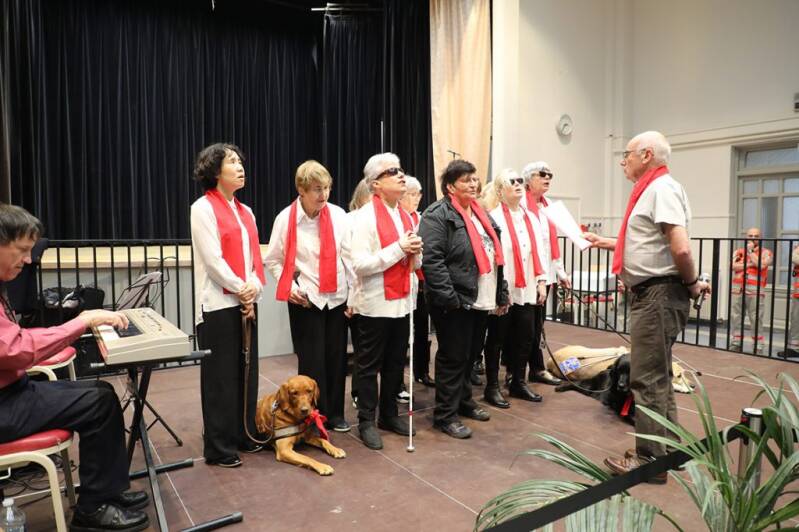 Photo de la chorale vue de face, avec son chef.