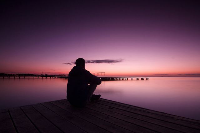 A man looking over the water. Thinking about the unhealthy relationship he is in.