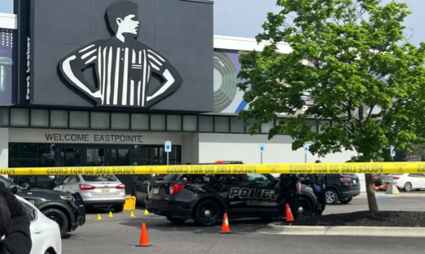 Police and caution tape outside Foot Locker in Eastpointe, Michigan after a fatal shooting, highlighting the scene of a tragic, real-world event.