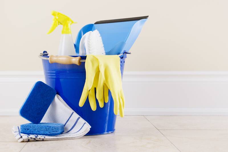 A blue bucket with various cleaning items 