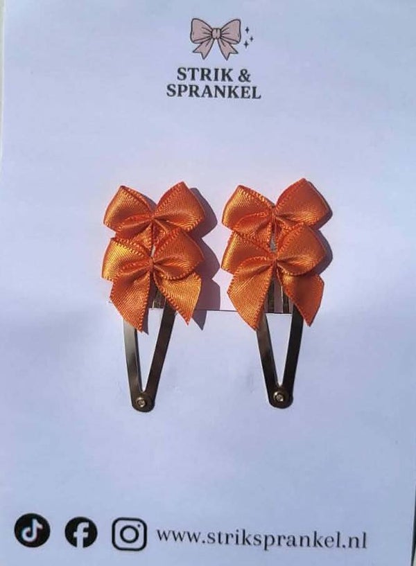 Speldje oranje strikjes