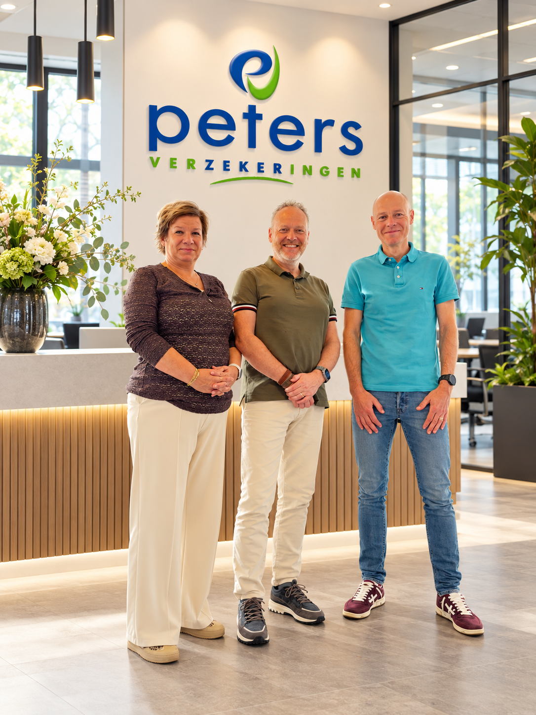 Het team van Peters Verzekeringen in een modern kantoor met het Peters Verzekeringen-logo op de achtergrond