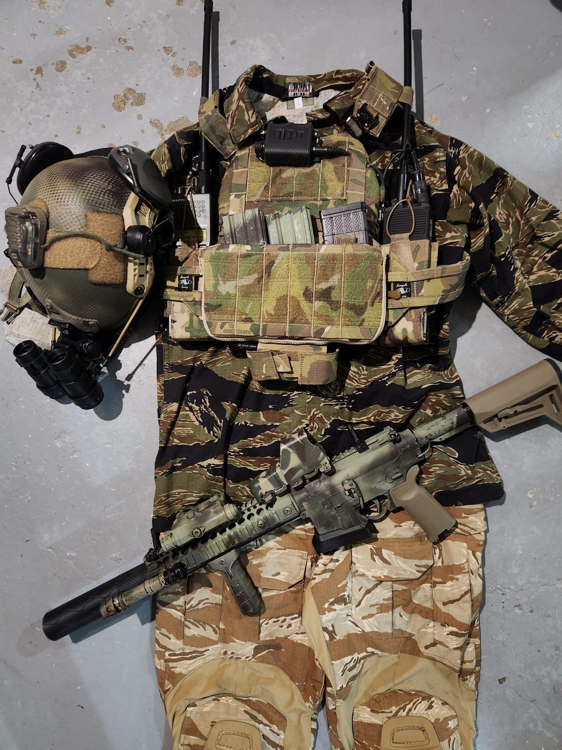 Renegade sewing multicam JTAC plate carrier pictured as part of a kit layout. The JTAC Plate Carrier is wired with an mbitr as well as a 163 radio. Also pictured is a jungle tigerstripe top and desert tigerstripe bottoms in crye style. Ar 15