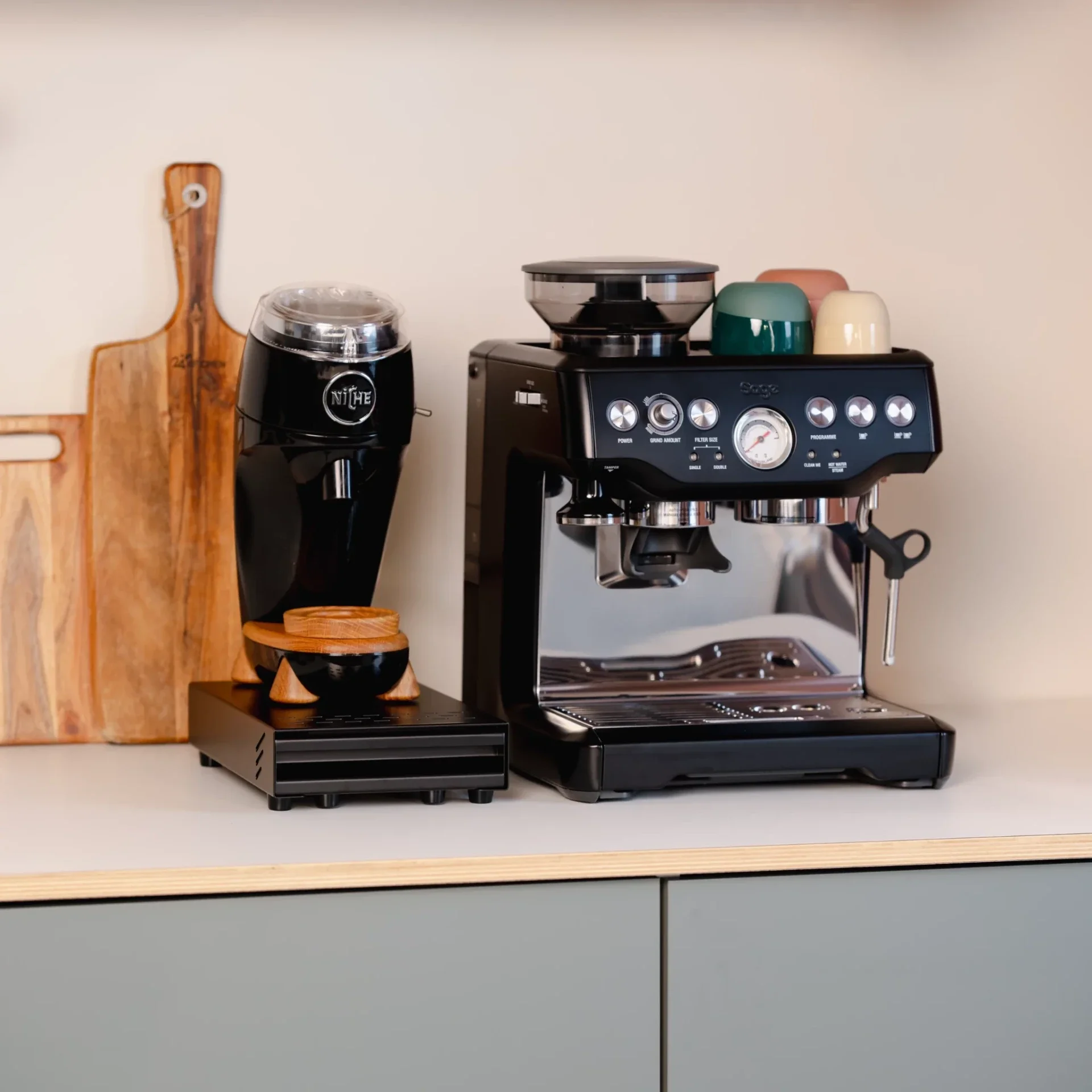 Mini uitkloplade zwart onder een Bezzera koffiemolen in een complete thuisbarista setup met espressomachine