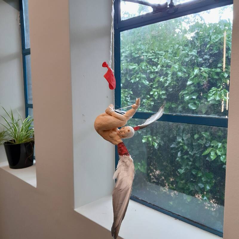 De zus van Icarus (Icarus' sister). 2026. Ceramics, acrylic paint, duck wings, wax, rope, balloon. 15 x 15 x 58 cm.