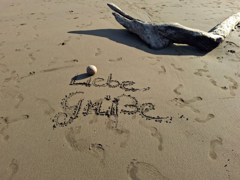 „Liebe Grüße“ in den Sand geschrieben an einem Strand in Costa Rica.