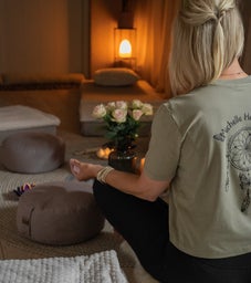 2 handen die schaal vast houden met salie, reinigende werking. En kaartendeck eronder, met spirituele wijsheden en inzichten