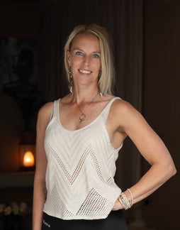 Blonde vrouw die je ziet van de zijkant met haar handen in namaste, yoga pose wat staat voor dankbaarheid