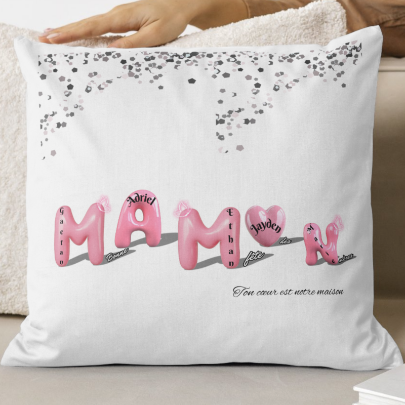 Housse de coussin personnalisée Fête des Mères avec lettres ballons roses formant “MAMAN”, prénoms des enfants intégrés dans chaque lettre, confettis argentés en haut et message au choix en bas.