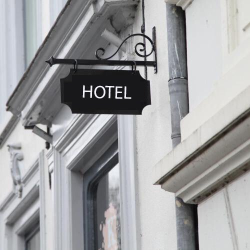 Vrouw wijst man nieuw beeld aan voor de hotel website op het beeldscherm van de computer