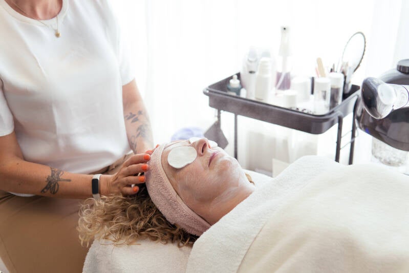 Klant (vrouw) tijdens het inwerken van gezichtsmasker, een hoofdmassage krijgt