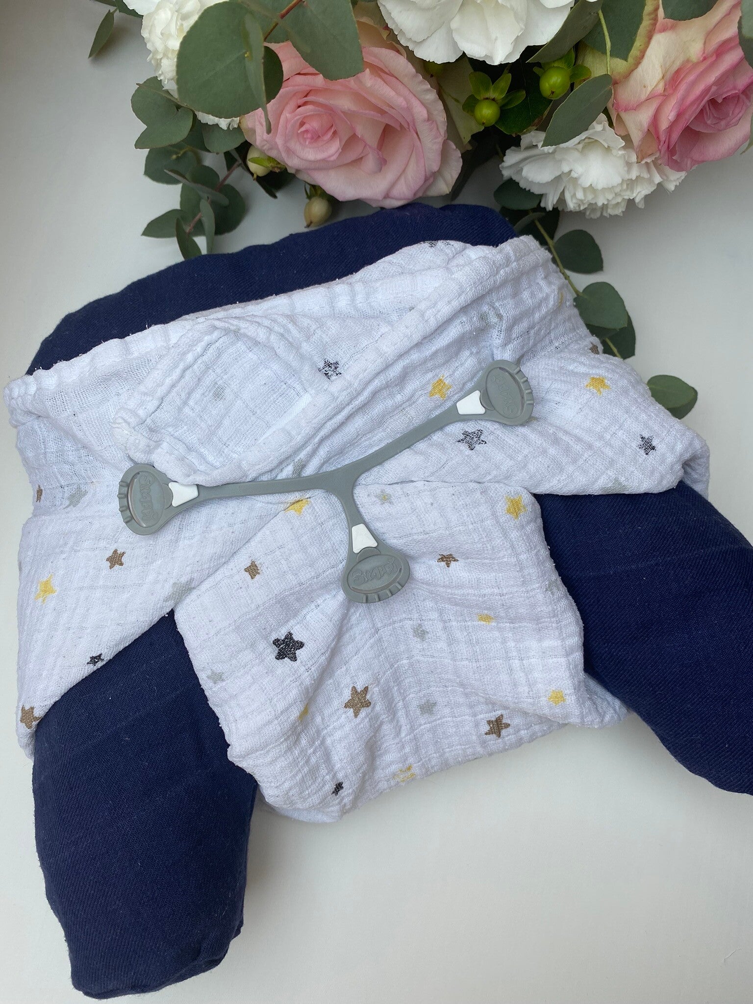 Wickeldummy mit Mullwinel, Snappy vor weißem Hintergrund und Rosen, In Liebe gewickelt, Stoffwindelberatung