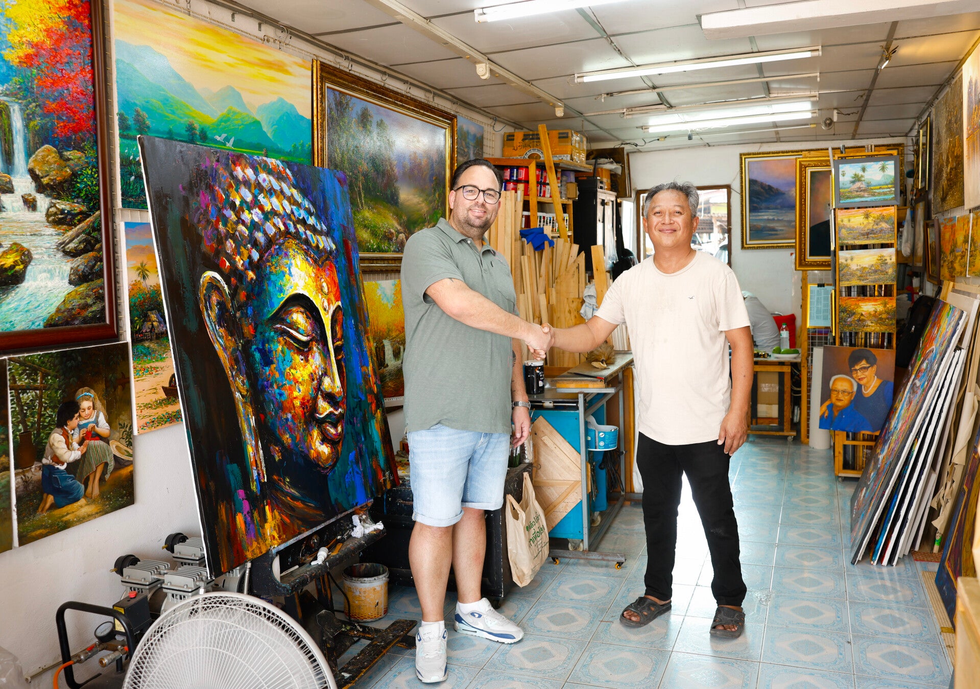 Alex Brandt en kunstenaar Seksak Jaichumchen schudden elkaar de hand in zijn kunstgalerie in Thailand