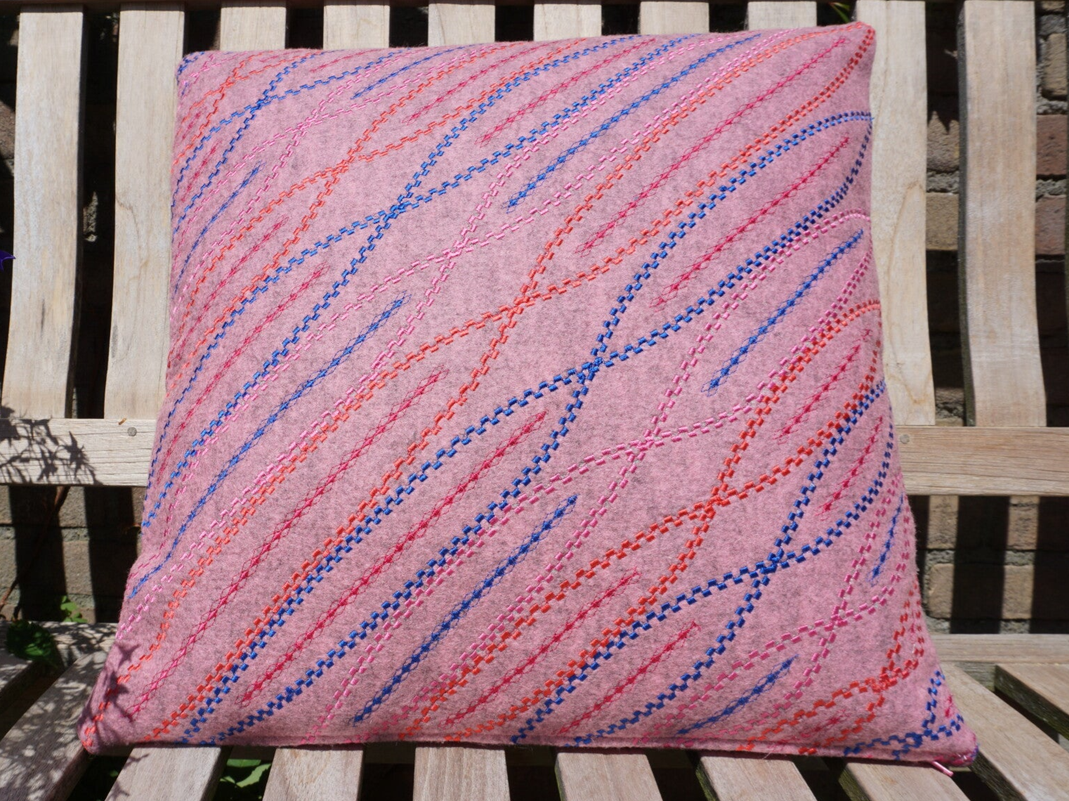 Roze kussen van bio vilt met siersteken