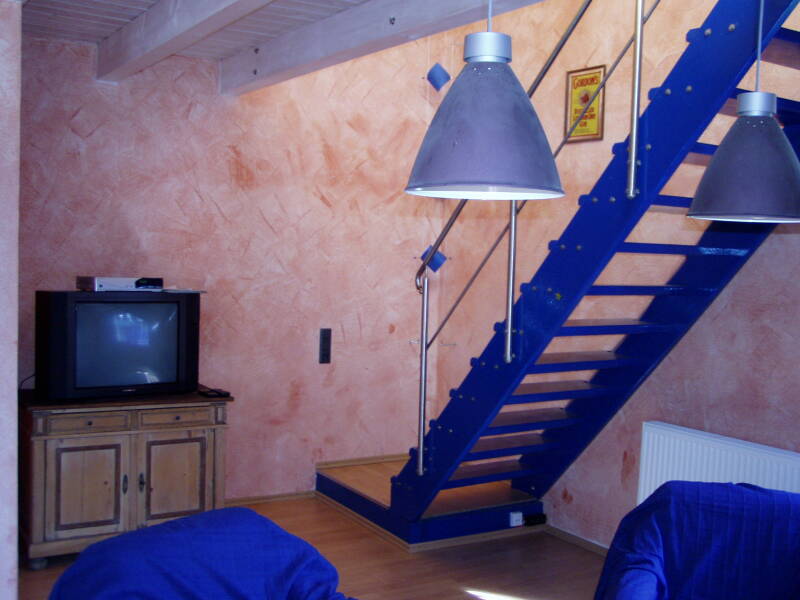 Wohnbereich mit TV und Aufgang in die obere Etage