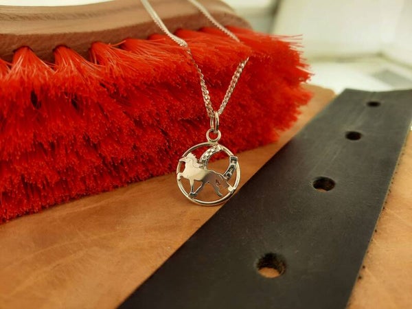 Hanger töltend paard met hoefijzer