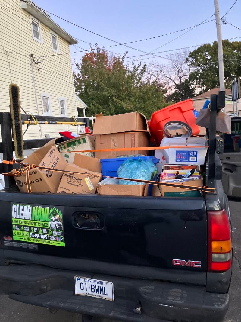 Clear Haul pickup truck loaded with boxes, bins, and household items for haul-away.