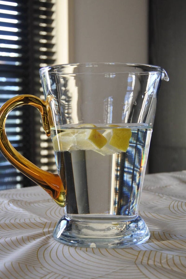 Vintage karaf van glas met cognackleurig handvat