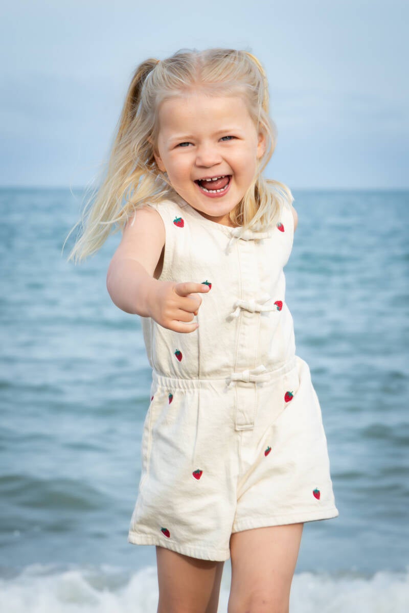 Child running on the beach during a family photography session in Benalmadena