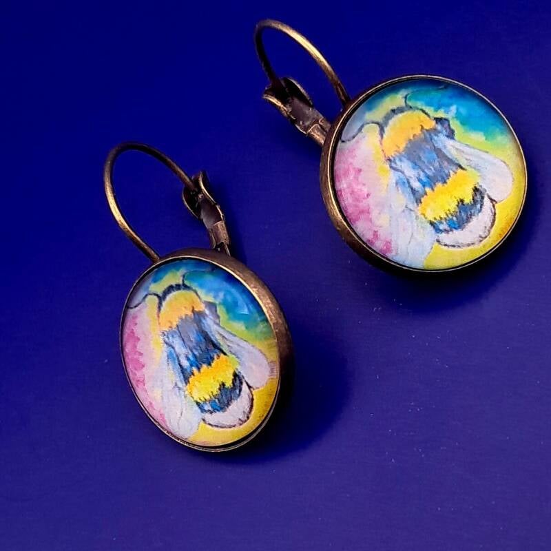 Earrings featuring vibrant  bee artwork under glass cabochons, hypoallergenic  antique bronze. Measure 2cm.  Price 20€