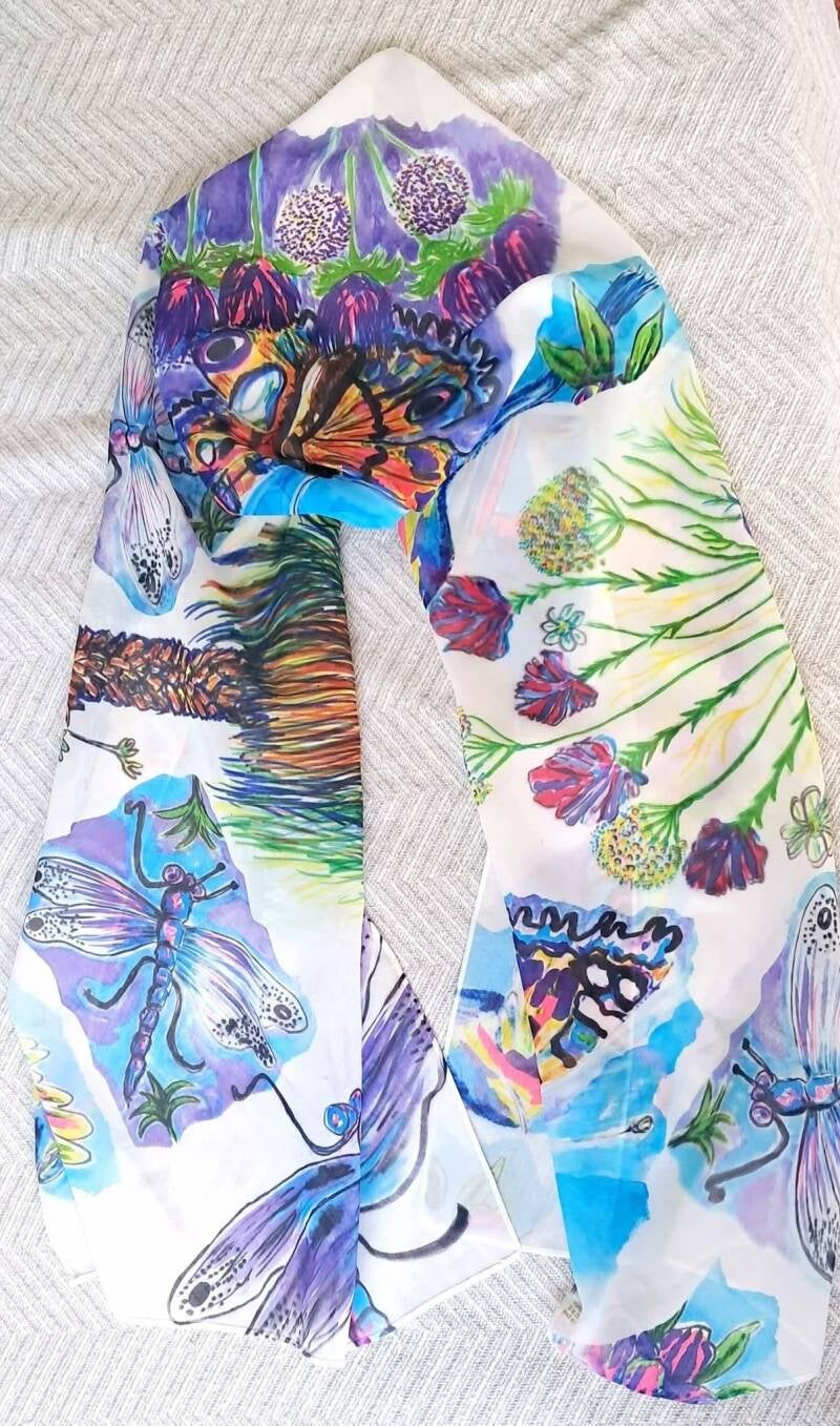 This lightweight polyester scarf features a vivid, hand-painted watercolour design of colourful butterflies, hummingbirds, dragonflies, and tropical flora on a white background Price 30€