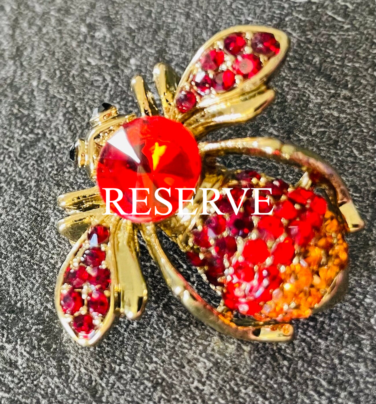 BROCHE EN METAL DORE ET STRASS DE COULEUR