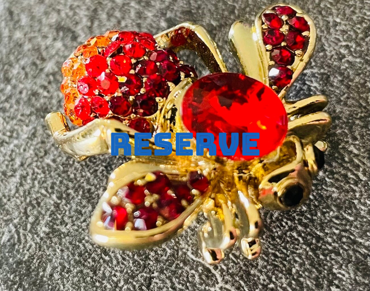 BROCHE EN METAL DORE ET STRASS DE COULEUR
