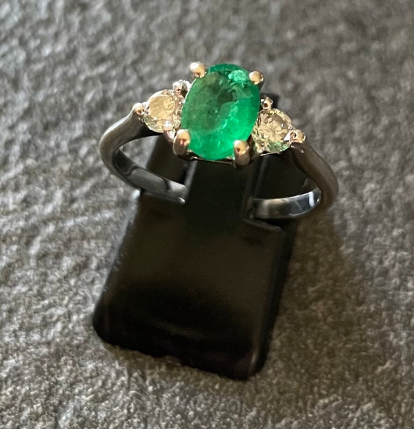 BAGUE EN OR GRIS 750/1000, SERTIE D’UNE EMERAUDE OVALE, ÉPAULEE DE DEUX DIAMANTS D’ENVIRON 0,05 CT CHACUN. - XX°