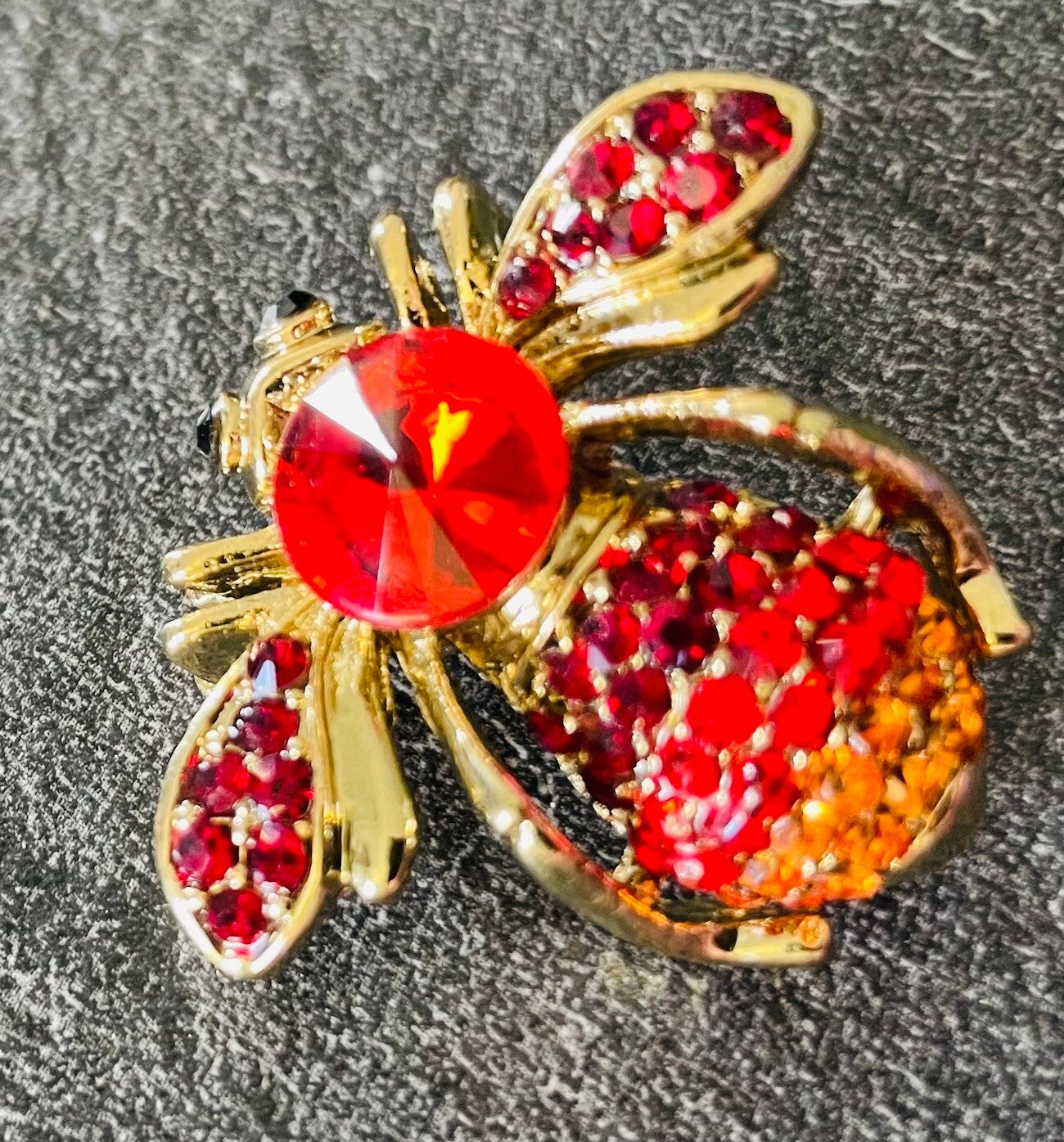 BROCHE EN METAL DORE ET STRASS DE COULEUR