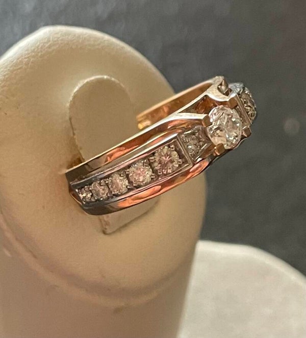 BAGUE EN OR JAUNE ET GRIS 18K SERTIE D’UN DIAMANT D’ENVIRON 0,25 CARAT ÉPAULÉ PAR UNE LIGNE DE DIAMANTS EN CHUTE
