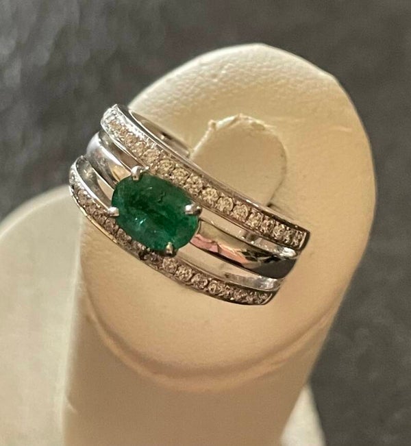 BAGUE EN OR GRIS 18K SERTIE D’UNE EMERAUDE OVALE EPAULÉE PAR DEUX LIGNES DE DIAMANTS - XX°