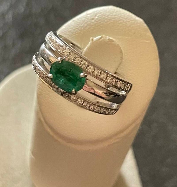 BAGUE EN OR GRIS 18K SERTIE D’UNE EMERAUDE OVALE EPAULÉE PAR DEUX LIGNES DE DIAMANTS - XX°