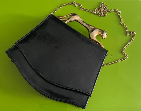 SAC EN CUIR NOIR TRAPÉZOIDALE, POIGNEE  PANTHÈRE METAL DORE - CIRCA 1970