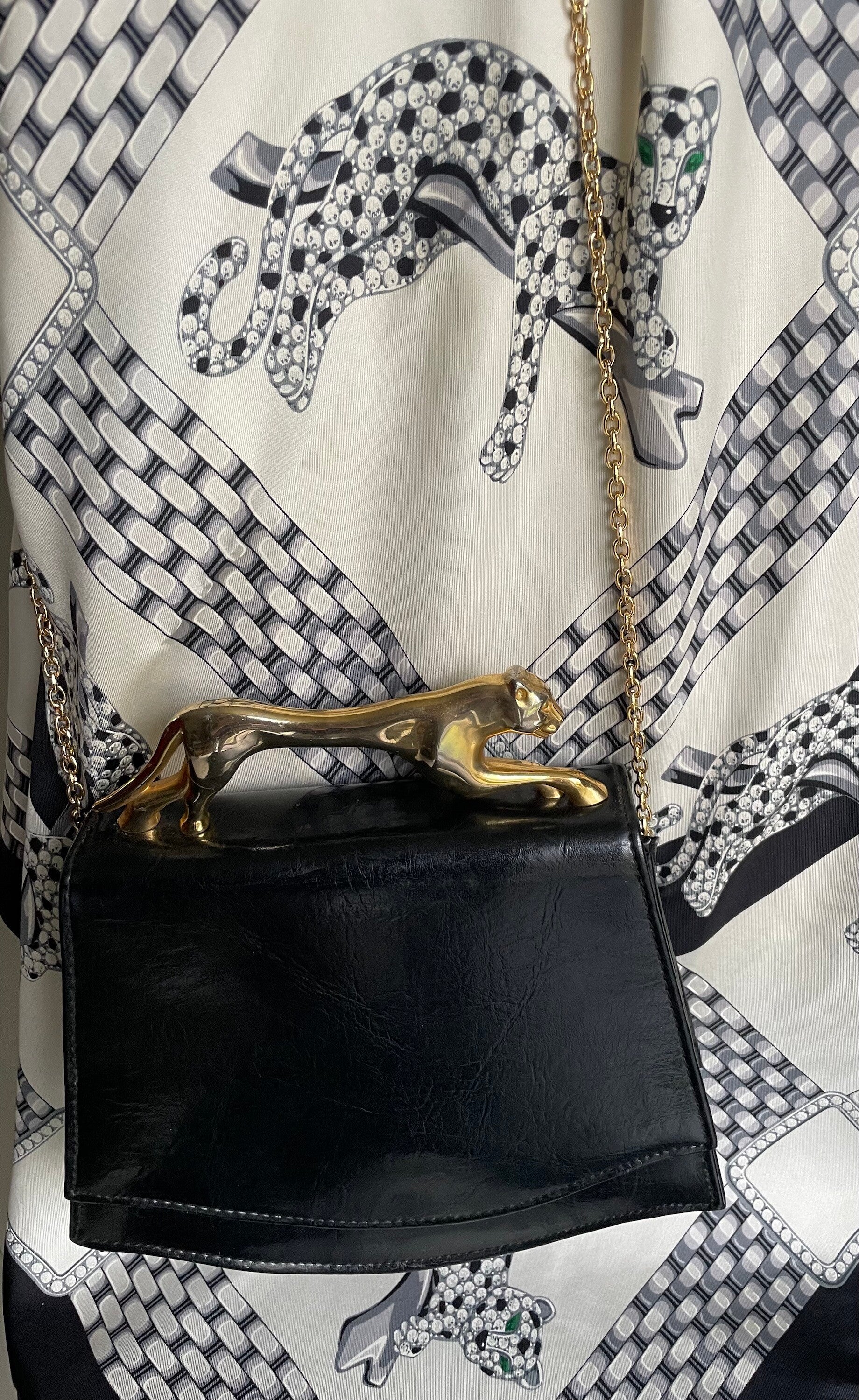 SAC EN CUIR NOIR TRAPÉZOIDALE, POIGNEE  PANTHÈRE METAL DORE - CIRCA 1970