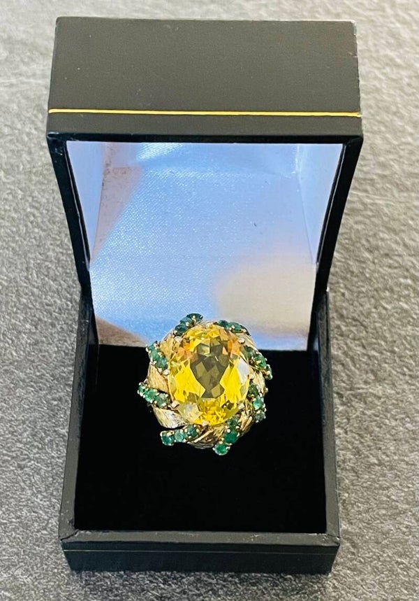 BAGUE OR JAUNE 18K SERTIE D’UNE IMPORTANTE CITRINE OVALE ENTOURÉE DE 24 EMERAUDES