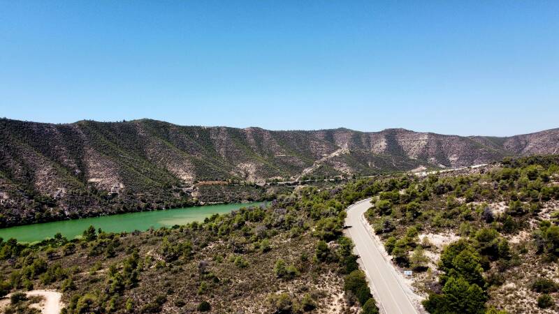 Bochtige weg langs een blauw meer – natuurroute in Spanje of Frankrijk