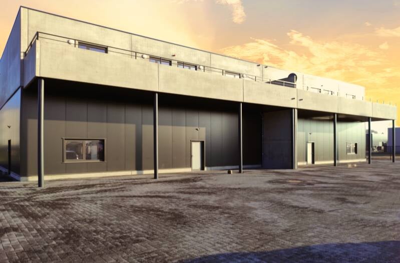 Grijze magazijnhal bij ondergaande zon – B2B vastgoedshoot