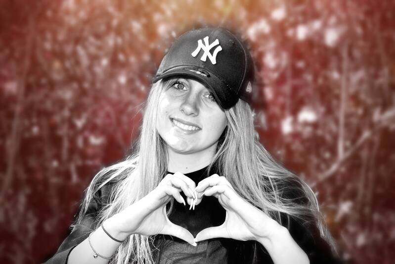 Tienermeisje met pet vormt hartje met handen – vrolijk portret voor jongerenfotografie